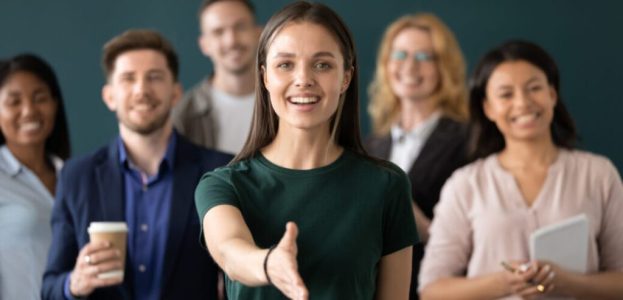 Woman company representative holds out hand for handshake welcoming client Woman company representative holds out hand for handshake welcoming client