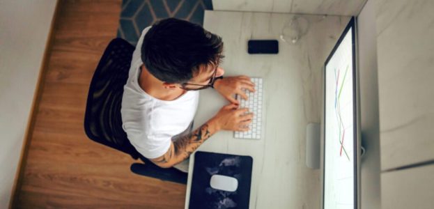 Top view of busy freelancer sitting at home office and typing on keyboard. Top view of busy freelancer sitting at home office and typing on keyboard.