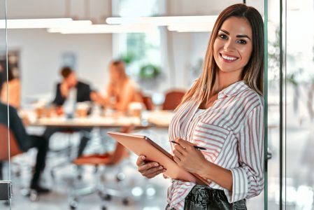 Portrait of a smiling young businesswoman using tablet in the office Portrait of a smiling young businesswoman using tablet in the office