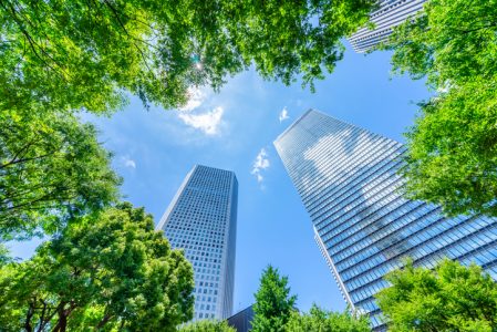 looking up view of panoramic modern city skyline with blue sky and green tree in shinjuku, tokyo, japan empresas