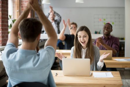 Office colleagues congratulating happy woman excited by good news online Office colleagues congratulating happy woman excited by good news online