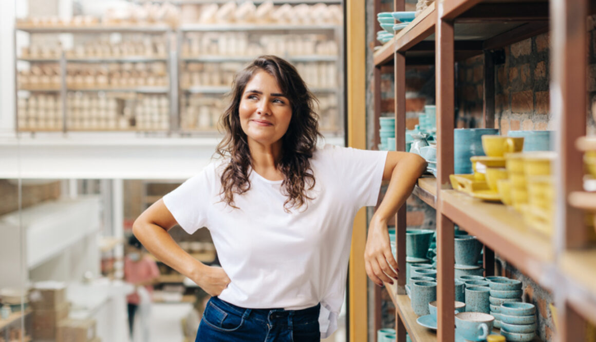 Cheerful ceramic store owner contemplating new creative ideas