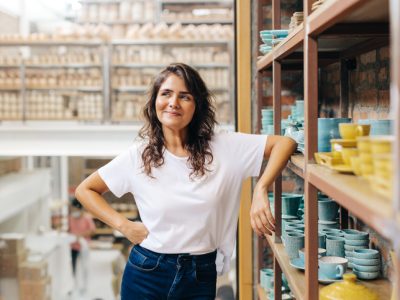 Cheerful ceramic store owner contemplating new creative ideas