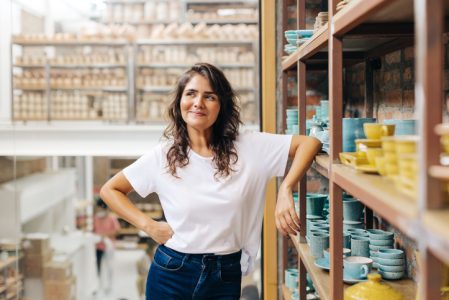 Cheerful ceramic store owner contemplating new creative ideas Cheerful ceramic store owner contemplating new creative ideas