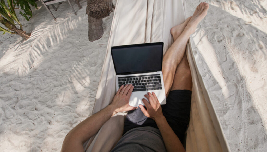 workation, remote work, freelancer with laptop in hammock