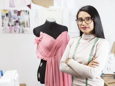 Portrait of a Hispanic fashion designer in her studio with her arms crossed- businesswoman