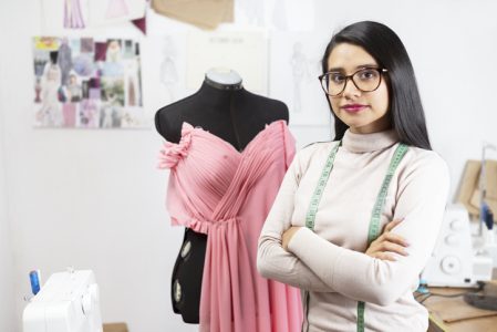 Portrait of a Hispanic fashion designer in her studio with her arms crossed- businesswoman Portrait of a Hispanic fashion designer in her studio with her arms crossed- businesswoman