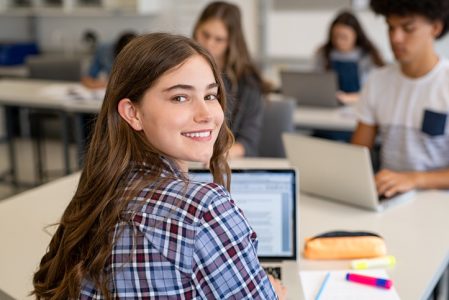 Happy smiling college girl studying on laptop Happy smiling college girl studying on laptop