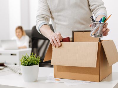 Upset office manager packing the box and leaving the office